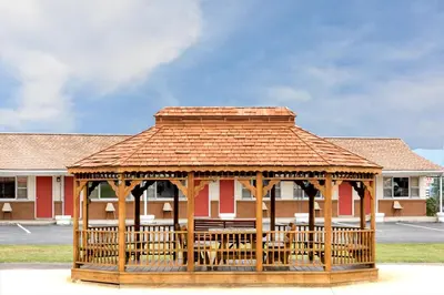 a wooden gazebo in front of a building at Budget Inn Mifflintown in Mifflintown