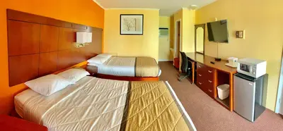 a hotel room with two beds and a flat screen tv at Budget Inn Mifflintown in Mifflintown