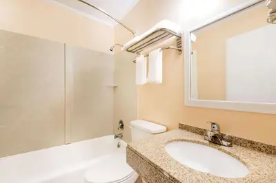 a bathroom with a sink and a toilet and a mirror at Budget Inn Mifflintown in Mifflintown