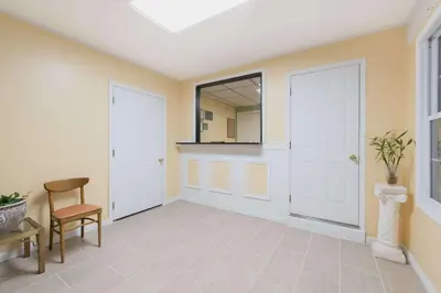 a hallway with two white doors and a chair at Budget Inn Mifflintown in Mifflintown