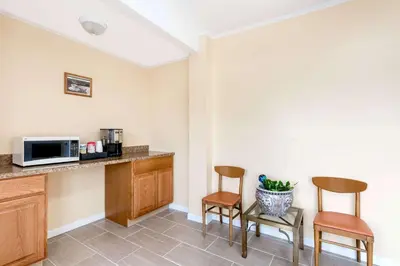 a kitchen with two chairs and a counter with a microwave at Budget Inn Mifflintown in Mifflintown