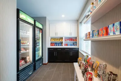 a store aisle with a refrigerator and shelves of food at Homewood Suites by Hilton Philadelphia-Valley Forge in Audubon