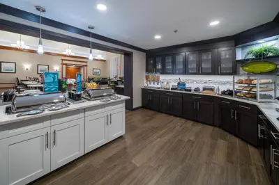 a large kitchen with white cabinets and wooden floors at Homewood Suites by Hilton Philadelphia-Valley Forge in Audubon