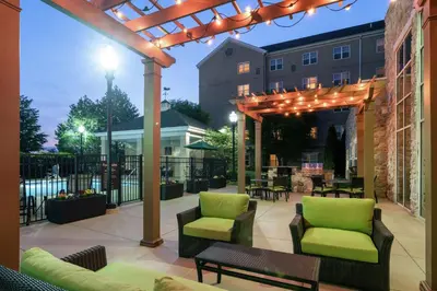 a patio with chairs and a pergola with lights at Homewood Suites by Hilton Philadelphia-Valley Forge in Audubon