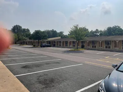 an empty parking lot with a row of buildings at Superlodge in New Castle
