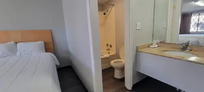 a bathroom with a bed and a sink and a toilet at Superlodge in New Castle