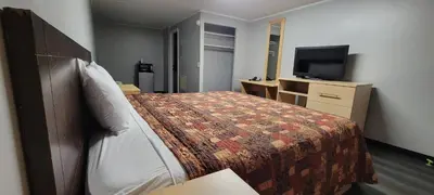 a hotel room with a bed and a flat screen tv at Superlodge in New Castle