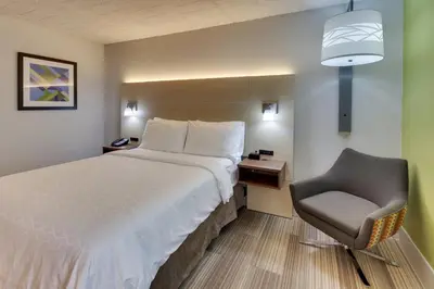 a hotel room with a bed and a chair at Holiday Inn Express Pittston - Scranton Airport by IHG in Pittston