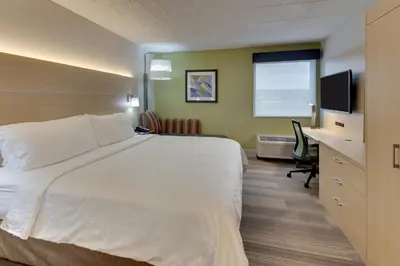 a hotel room with a bed and a desk and a television at Holiday Inn Express Pittston - Scranton Airport by IHG in Pittston