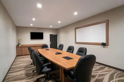 a conference room with a wooden table and chairs at Microtel Inn & Suites by Wyndham Carlisle in Carlisle