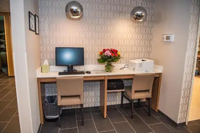 a desk with a computer and flowers on it at Microtel Inn & Suites by Wyndham Carlisle in Carlisle