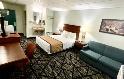 a hotel room with a bed and a couch at Knights Inn Paxinos Elysburg in Paxinos