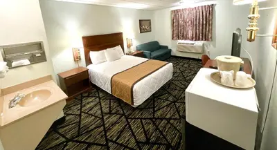 a hotel room with a bed and a sink at Knights Inn Paxinos Elysburg in Paxinos