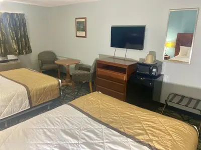 a hotel room with two beds and a flat screen tv at Knights Inn Paxinos Elysburg in Paxinos