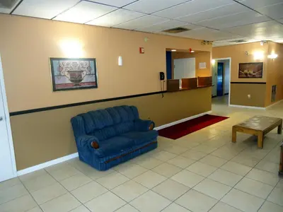 a waiting room with a blue chair and a table at Knights Inn Paxinos Elysburg in Paxinos