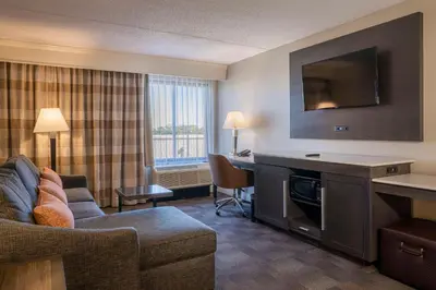 a living room with a couch and a desk in a hotel room at Hampton Inn Carlstadt At The Meadowlands in Carlstadt