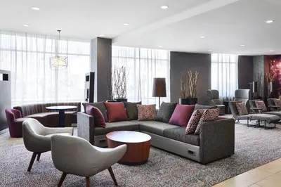 a living room with a couch and chairs and tables at Courtyard by Marriott Newark Downtown in Newark