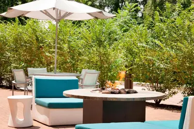 a patio with a table and chairs and an umbrella at SpringHill Suites by Marriott Philadelphia Langhorne in Langhorne