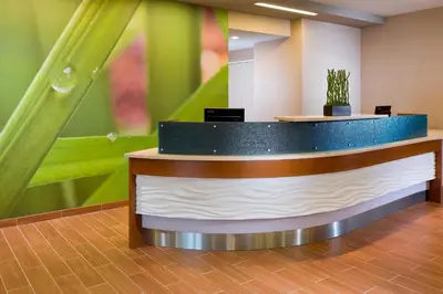 a lobby with a reception counter with green walls at SpringHill Suites by Marriott Philadelphia Langhorne in Langhorne
