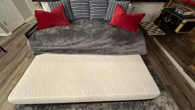 a couch with red pillows in a living room at Ski on Ski off Mtn Chalet in Vernon