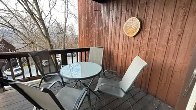 a patio with a table and chairs on a deck at Ski on Ski off Mtn Chalet in Vernon