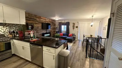 a kitchen with a counter top and a living room at Ski on Ski off Mtn Chalet in Vernon