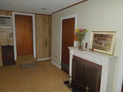 a living room with a fireplace with a vase of flowers on it at Slumberland Motel Mount Holly in Mount Holly