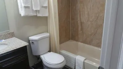 a bathroom with a toilet and a shower and a sink at Slumberland Motel Mount Holly in Mount Holly