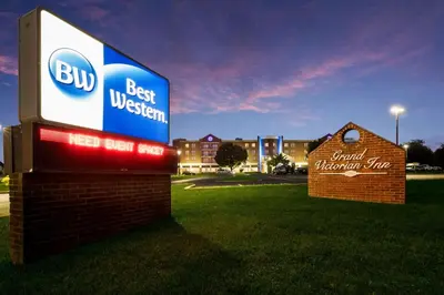 a sign for a best western hospital in a field at Best Western Grand Victorian Inn in Sayre