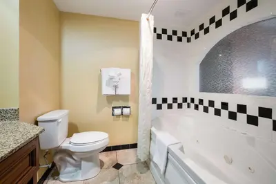 a bathroom with a toilet and a tub and a sink at Best Western Grand Victorian Inn in Sayre