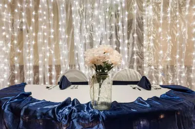 a table with a vase of flowers on it at Best Western Grand Victorian Inn in Sayre