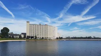a large white building next to a large body of water at Hilton Philadelphia City Avenue in Philadelphia