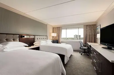 a hotel room with two beds and a flat screen tv at Hilton Philadelphia City Avenue in Philadelphia