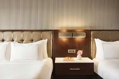 a hotel room with two beds and a table with flowers at Hilton Philadelphia City Avenue in Philadelphia