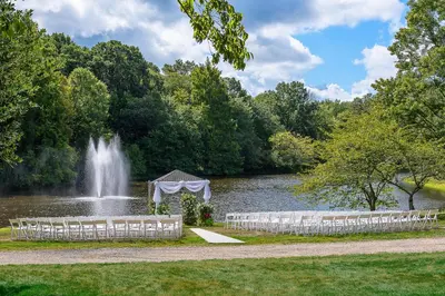 a wedding set up in front of a pond with a fountain at Holiday Inn Express Princeton Southeast by IHG in Plainsboro