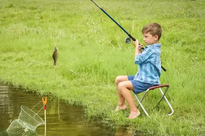 a young boy sitting in a chair holding a fishing rod at Holiday Inn Express Princeton Southeast by IHG in Plainsboro