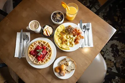 a table with plates of breakfast food on it at AmishView Inn & Suites in Bird in Hand