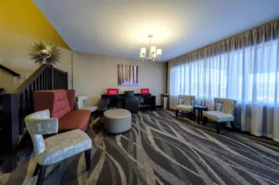 a lobby with a waiting room with chairs and tables at Red Roof Inn & Suites Newburgh - Stewart Airport West Point in New Windsor