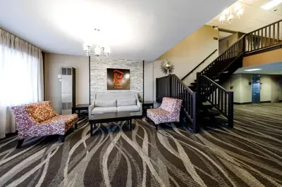 a living room with two chairs and a couch at Red Roof Inn & Suites Newburgh - Stewart Airport West Point in New Windsor
