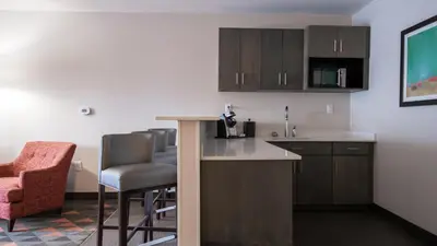 a kitchen with a counter and chairs in a room at Holiday Inn & Suites Philadelphia W - Drexel Hill by IHG in Drexel Hill