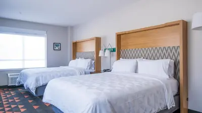a hotel room with two beds and a window at Holiday Inn & Suites Philadelphia W - Drexel Hill by IHG in Drexel Hill