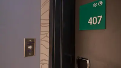 a door with a green exit sign on it at Holiday Inn & Suites Philadelphia W - Drexel Hill by IHG in Drexel Hill