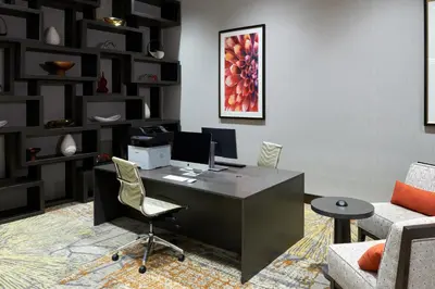 an office with a desk with a computer and a chair at Holiday Inn & Suites Philadelphia W - Drexel Hill by IHG in Drexel Hill