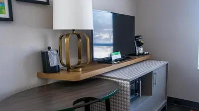a room with a desk with a keyboard and a lamp at Holiday Inn & Suites Philadelphia W - Drexel Hill by IHG in Drexel Hill