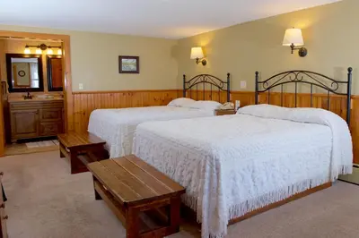a bedroom with two beds with white comforters at Myer Country Motel in Milford