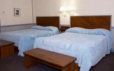 a hotel room with two beds with blue blankets at Myer Country Motel in Milford