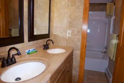 a bathroom with a sink and a shower and a tub at Myer Country Motel in Milford