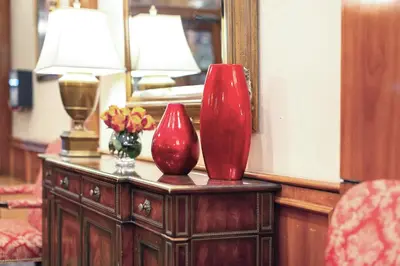 two red vases on a table in front of a mirror at Hotel St. James in New York