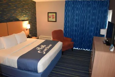 a hotel room with a bed and a chair at Days Inn by Wyndham Wayne in Wayne