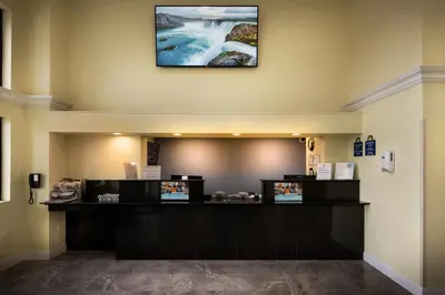a cashier counter in a lobby with a picture on the wall at Days Inn by Wyndham Wayne in Wayne